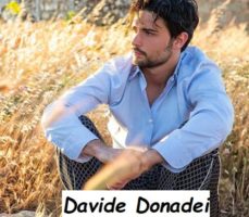 Foto del nuovo tronista di Uomini e donne Davide Donadei assorto a contemplare la bellezza di un campo di grano